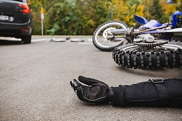 An injured man on the ground after a motorcycle accident.